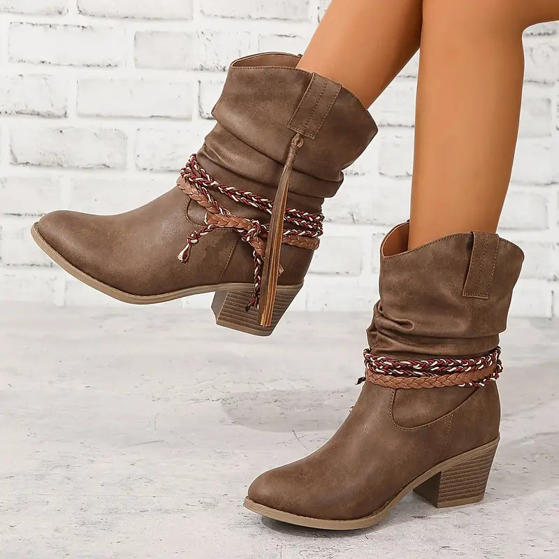 Side view of slouched shaft western ankle boot with braided wraps and tassels, block heel and pointed toe, brown