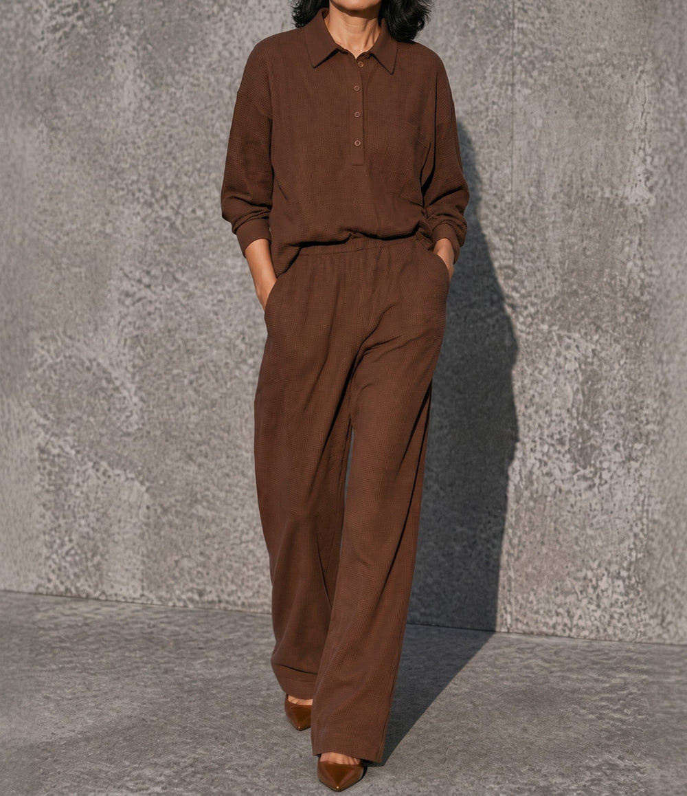 Front view showing collar, button placket, banded waist and wide legs, deep brown
