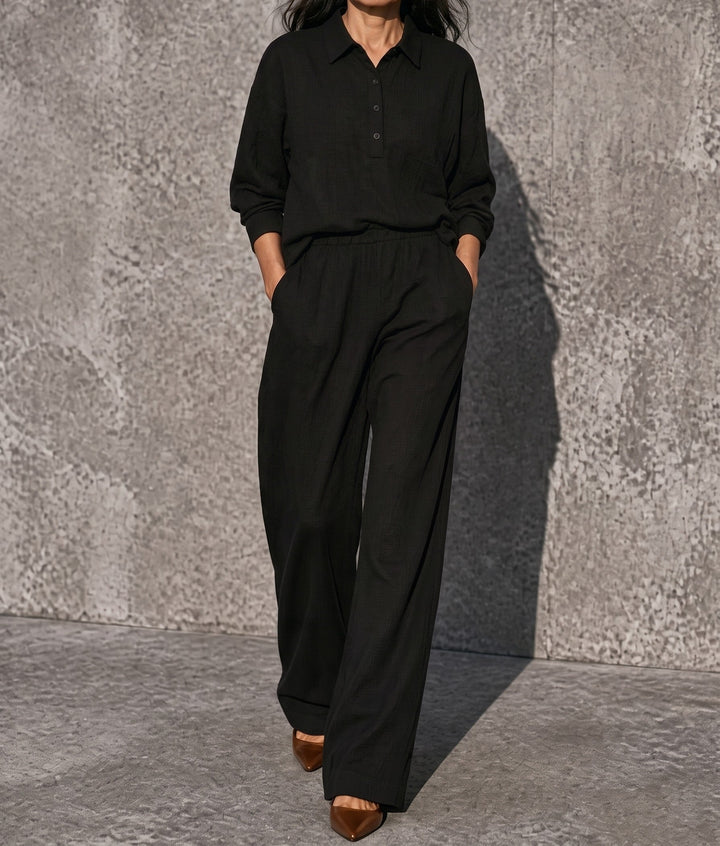Front view showing collar, side pockets and ankle-length hem, black