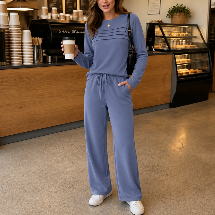 Front view of pleated bodice, long sleeves, drawstring waist and side pocket, blue