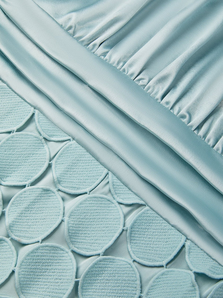 Detail view of the dress surface showing ruching and circle paillettes