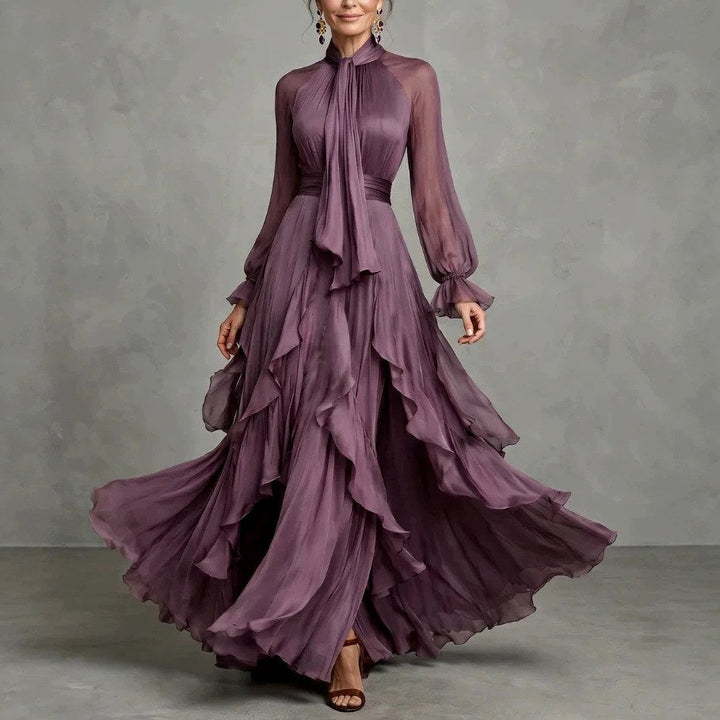 Front view of gathered high neckline with ties, long sleeves and ruffle layered skirt, purple