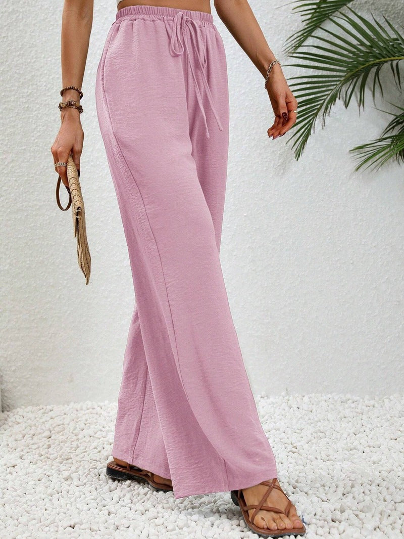 Front view of gathered banded waist with drawstring tie and wide legs, light pink