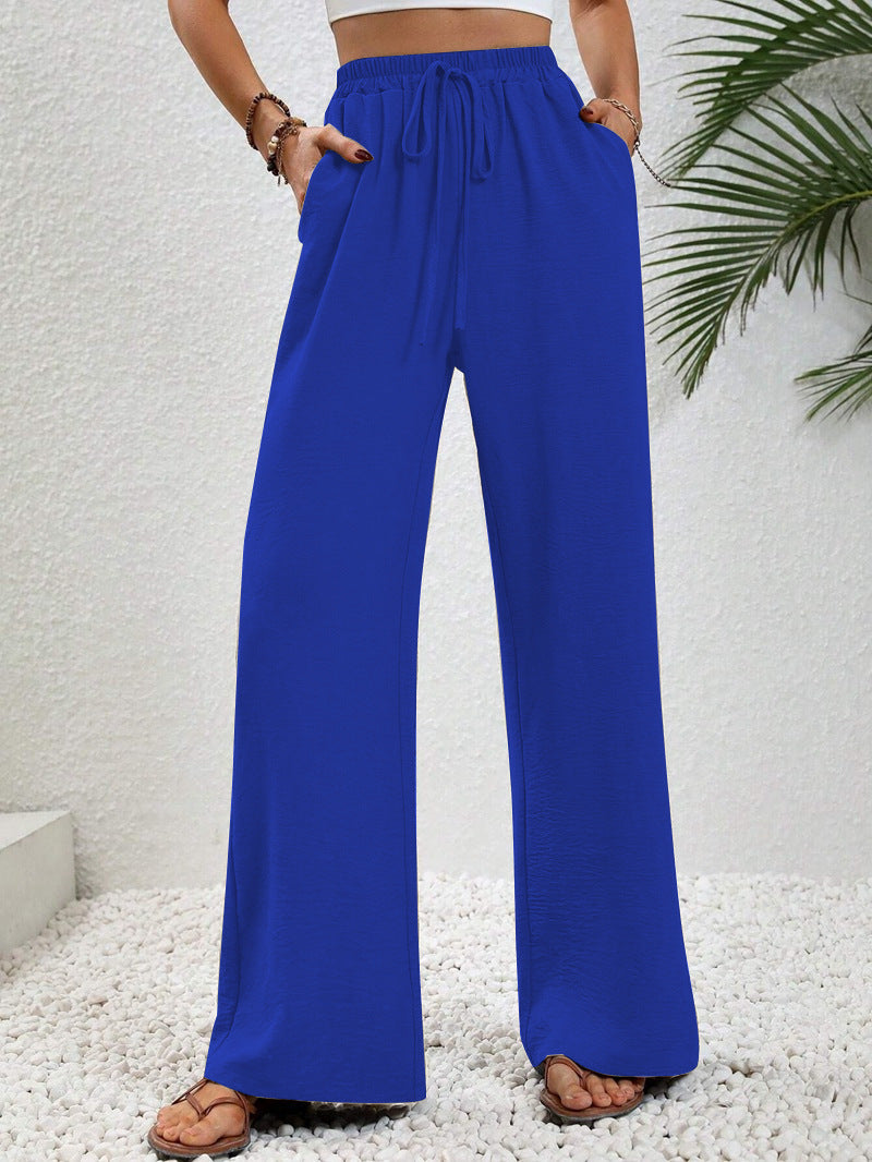 Front view of side pockets and gathered banded waist with drawstring tie, dark blue