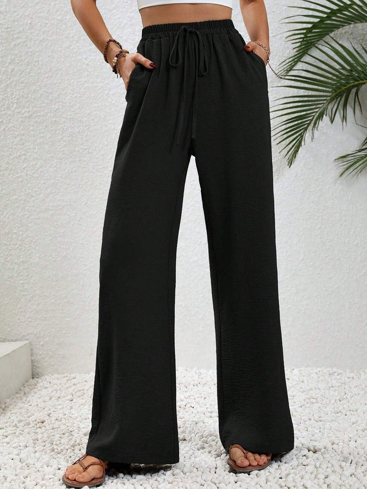 Front view of side pockets and gathered banded waist with drawstring tie, black