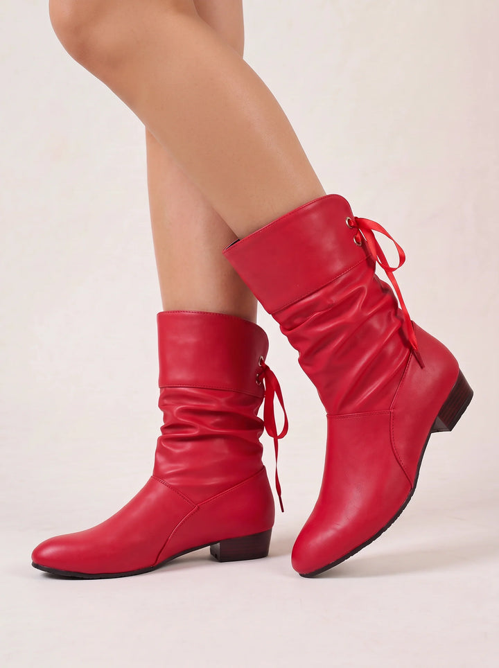 Side view of ruched shaft, bow tie back lacing and block heel, red