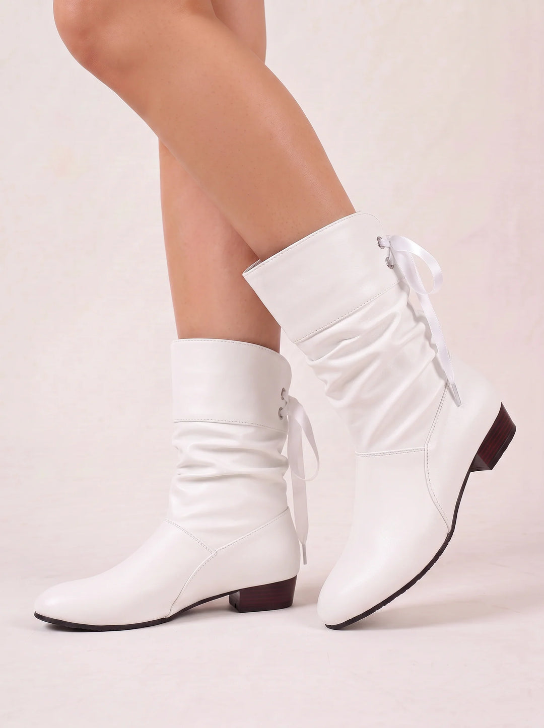 Side view of ruched shaft, back lacing and block heel, white