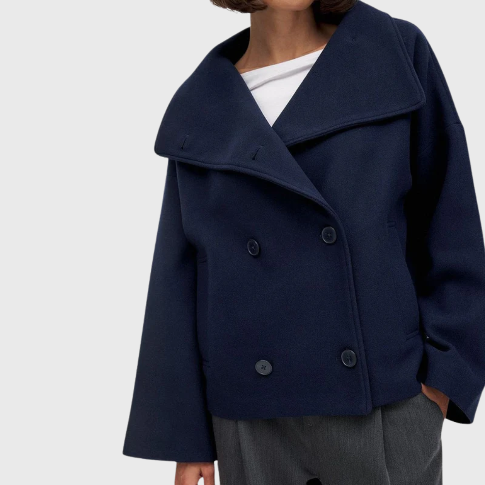 Side view showing wide lapels, double-breasted buttons and long sleeve, navy blue