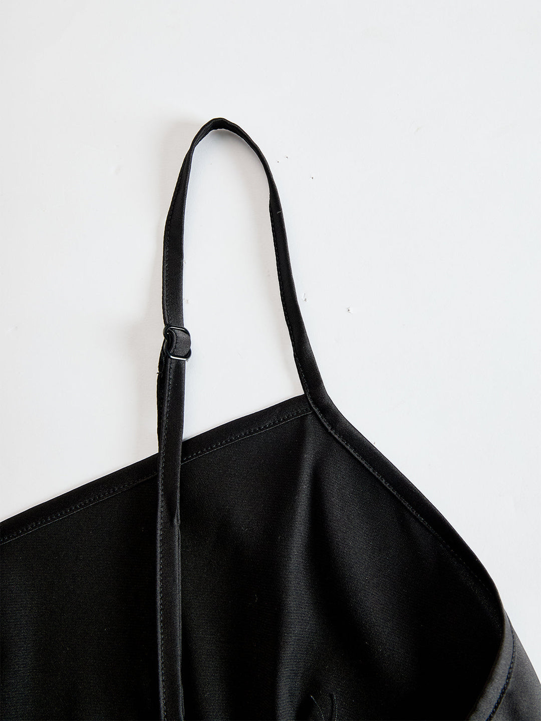 Detail view of adjustable spaghetti strap and sweetheart neckline of camisole