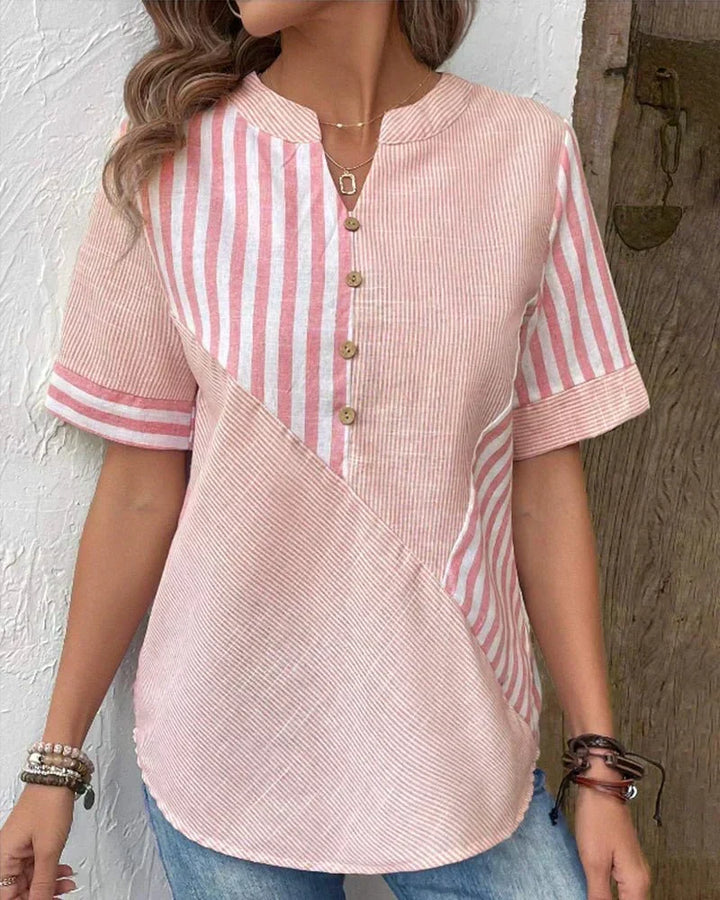 Front view showing notched neckline, button placket and curved hem