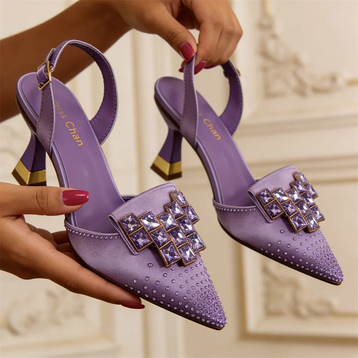 Detail view of jeweled buckle plate and studded pointed toe upper with slingback buckle