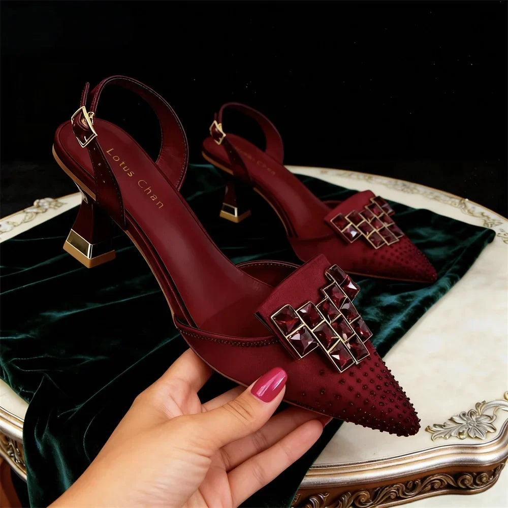 Side view of pointed toe heel with jeweled buckle plate and block heel