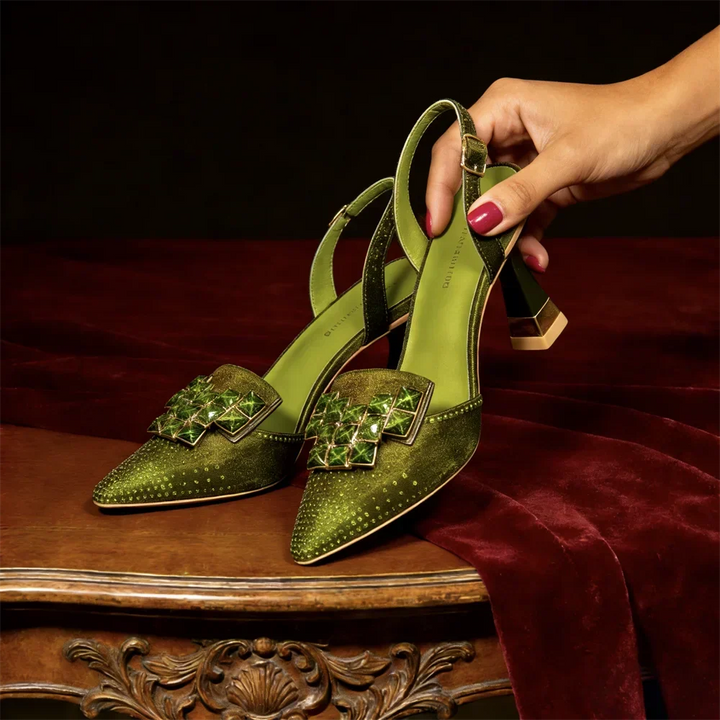 Side view of studded pointed toe heel with jeweled buckle plate and slingback strap