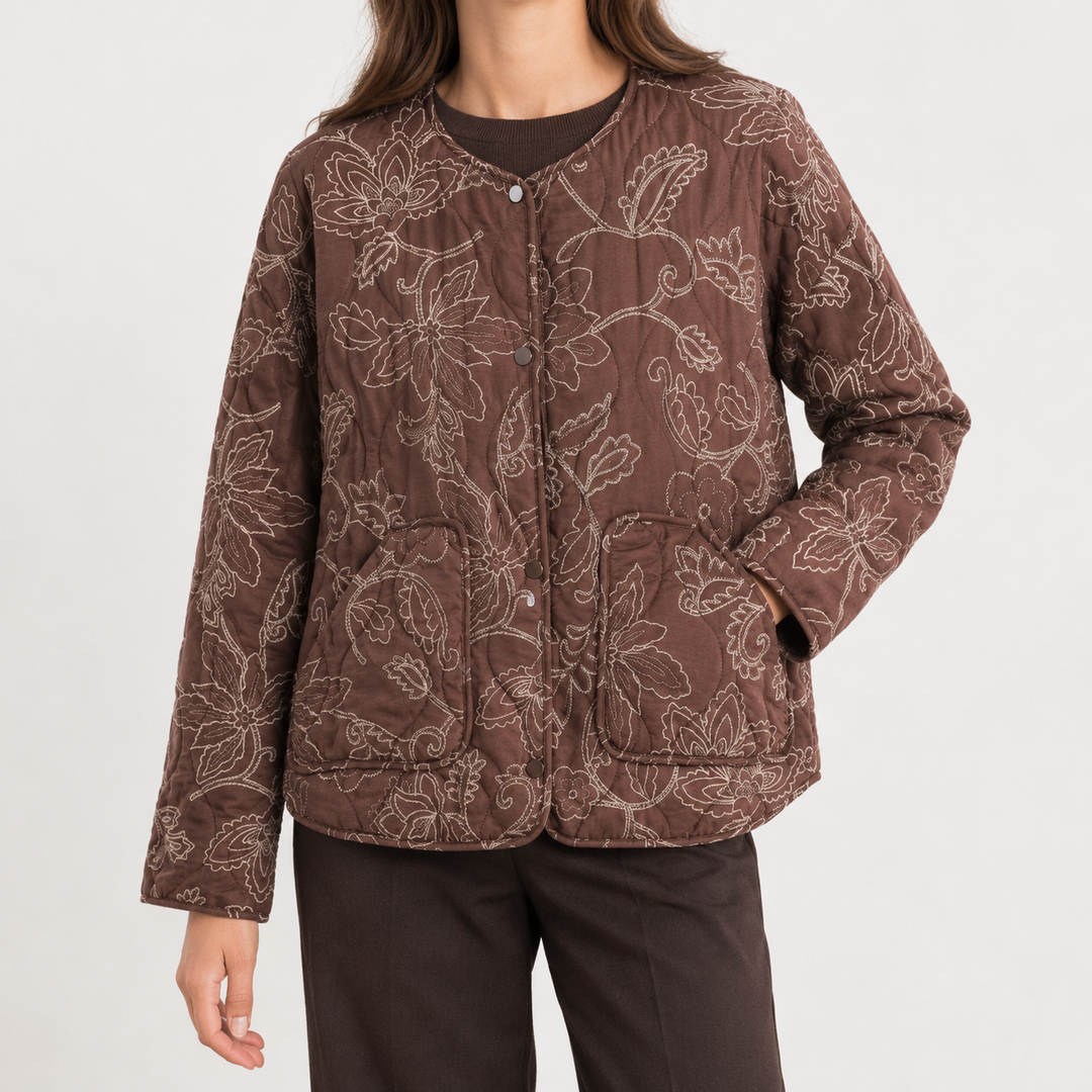 Front view of quilted jacket with round neckline, snap front placket, long sleeves and patch pockets, brown