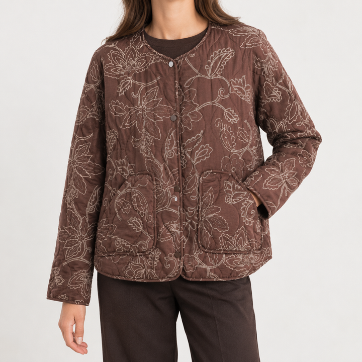 Front view of quilted jacket with round neckline, snap front placket, long sleeves and patch pockets, brown