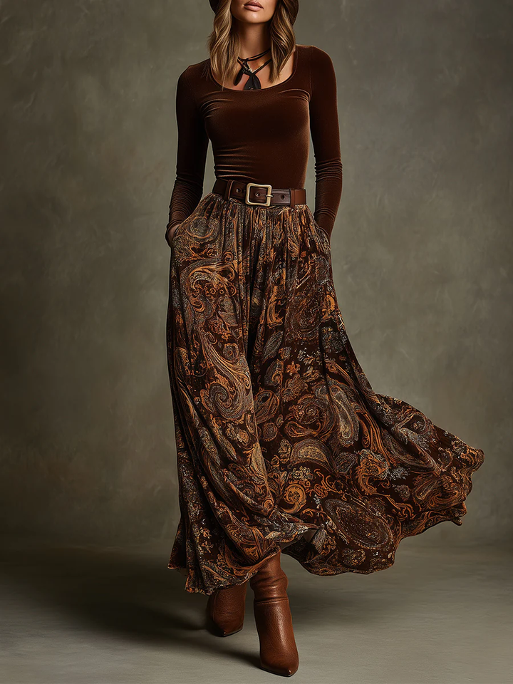 Front view of round neck long sleeve top with belted waist and floor-length paisley skirt, brown