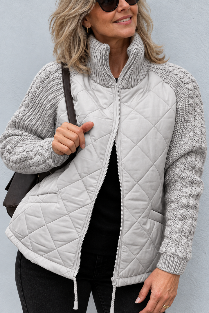 Front view with stand collar, cable sleeves, quilted body, side pocket and drawstring hem, gray