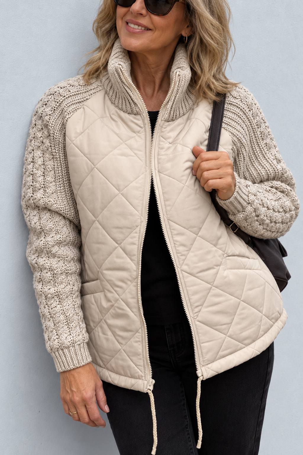 Front view with stand collar, quilted body, side pocket and drawstring hem with toggles