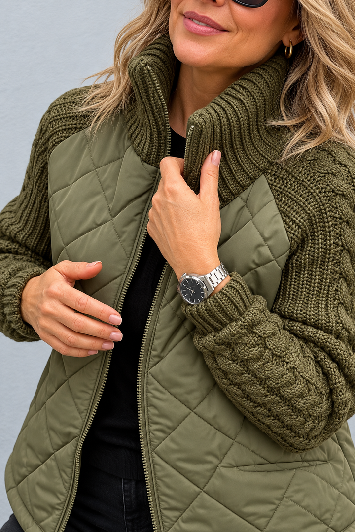Detail view of stand collar, cable sleeve with banded cuff, quilted body and front zipper