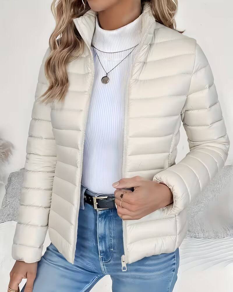 Front view showing stand collar, zipper closure and quilted body, cream