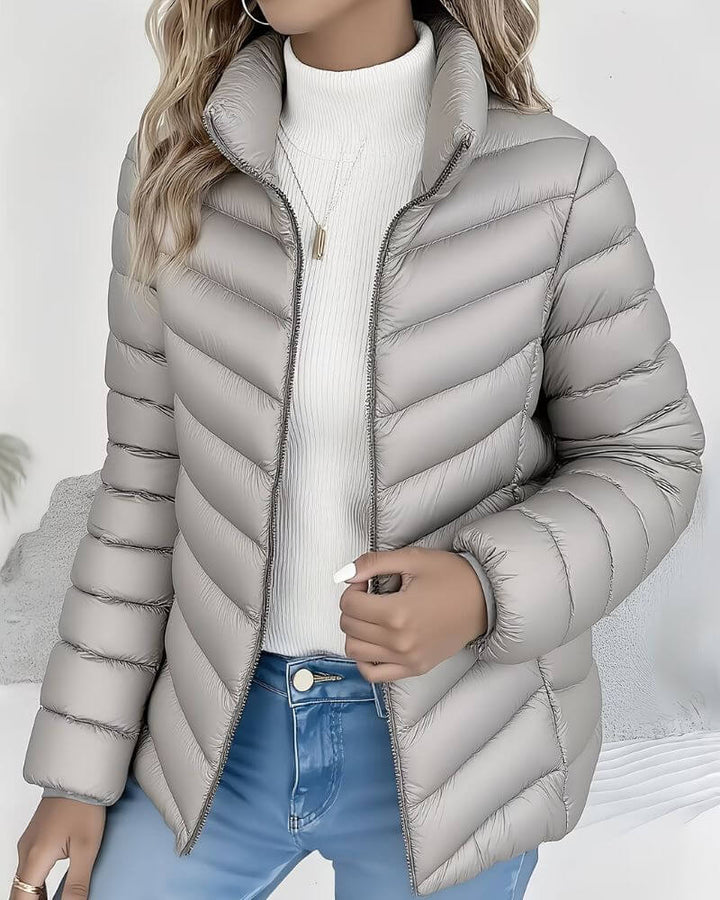 Side view showing stand collar, long sleeves and quilting, gray
