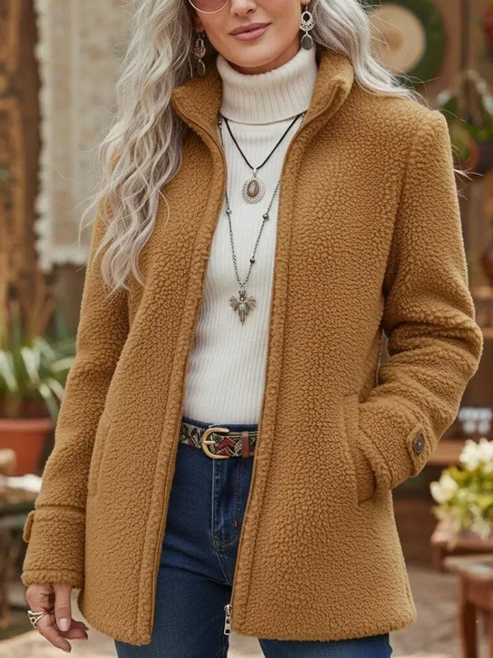 Front view showing stand collar, side pockets and button tab cuff, camel