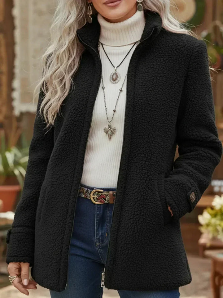 Front view showing stand collar, full-length zipper and side pockets, black