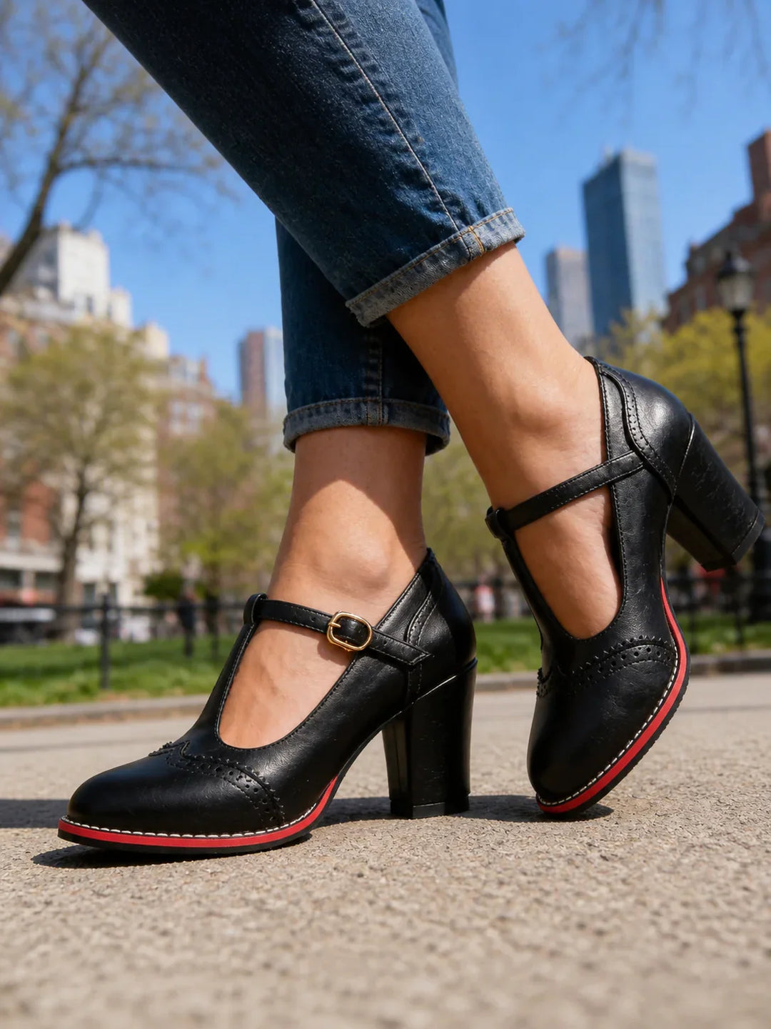 Side view of t-bar strap, buckle, brogue detailing and block heel