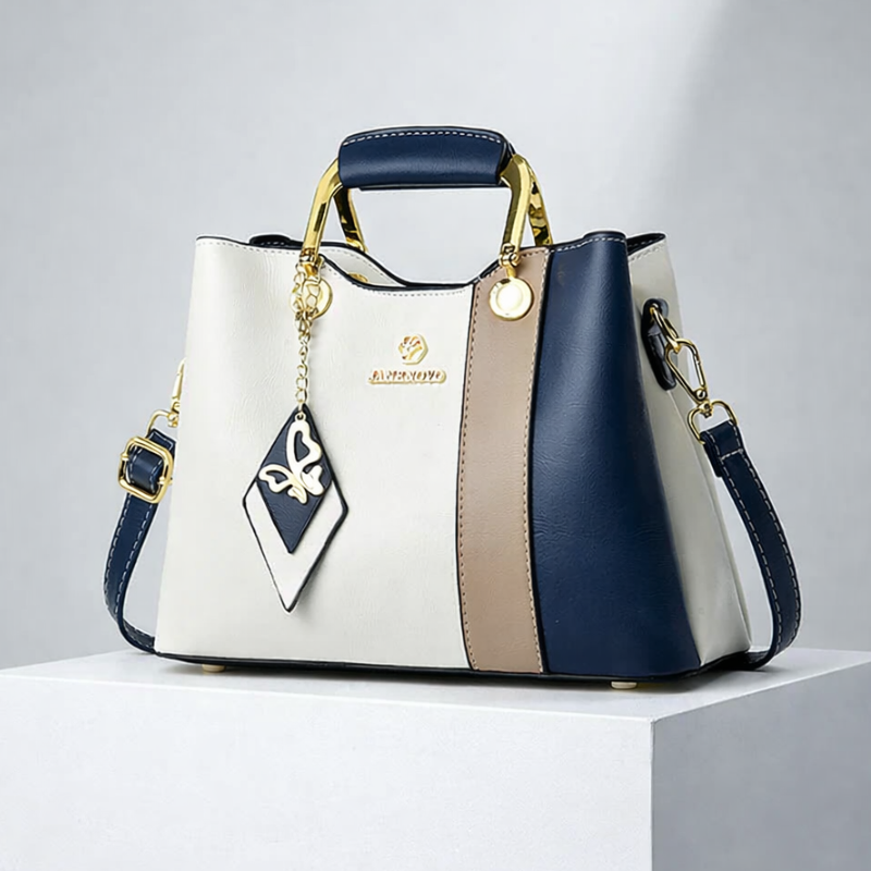 Front view of top handle, butterfly charm and crossbody strap, blue