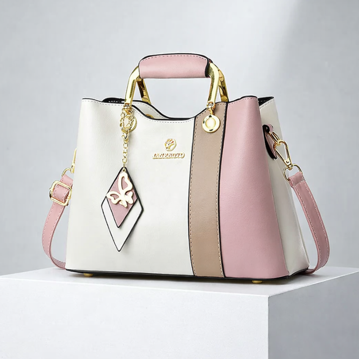 Front view of top handle, butterfly charm and color-block panels, pink &amp; white