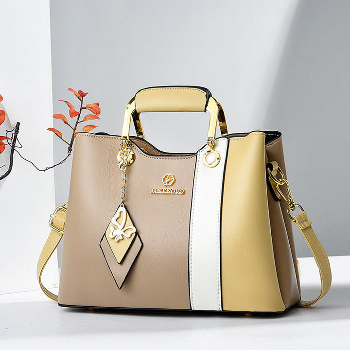 Front view of top handle, butterfly charm and crossbody strap