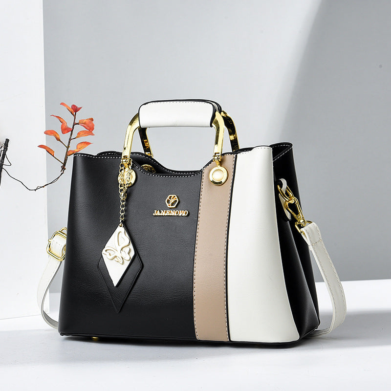 Front view of top handle, butterfly charm and crossbody strap