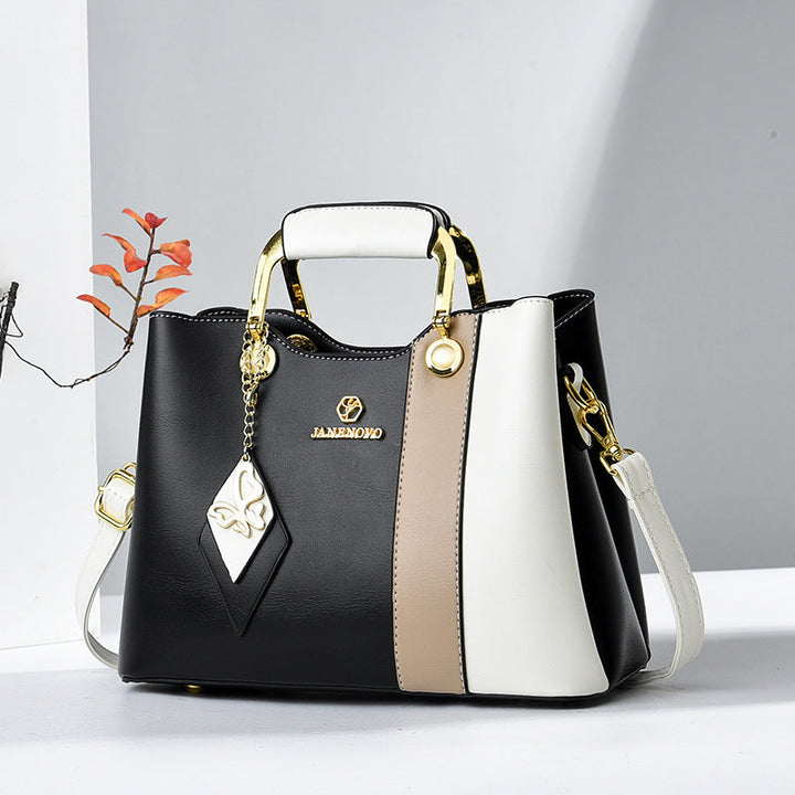 Front view of top handle, butterfly charm and crossbody strap