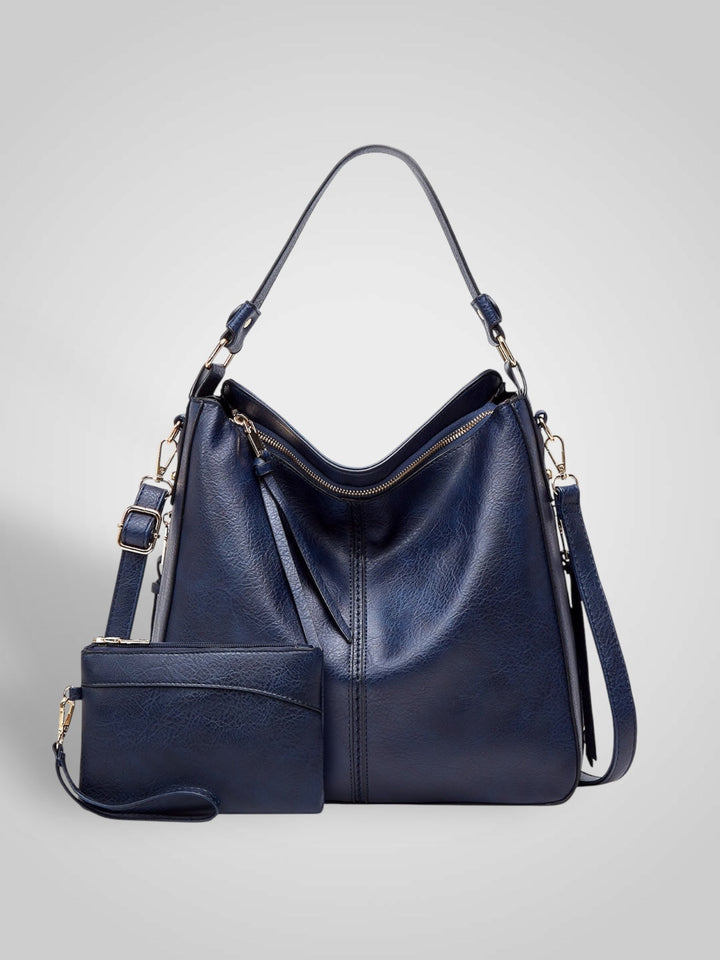 Front view with top handle, crossbody strap, top zipper closure and matching pouch, blue