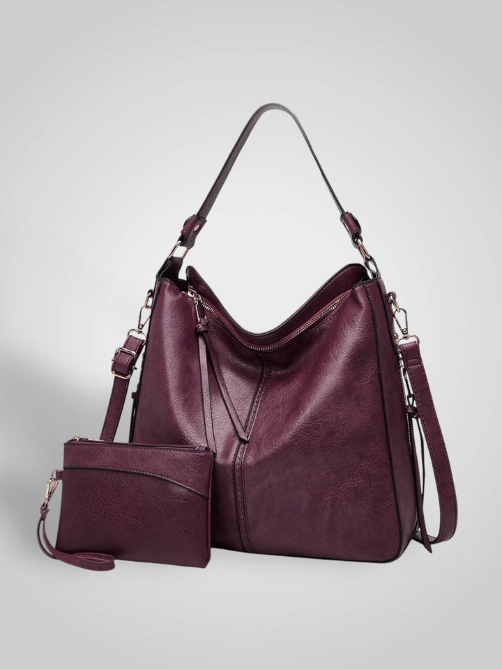Front view with top handle, crossbody strap, top zipper closure and matching pouch, bordeaux
