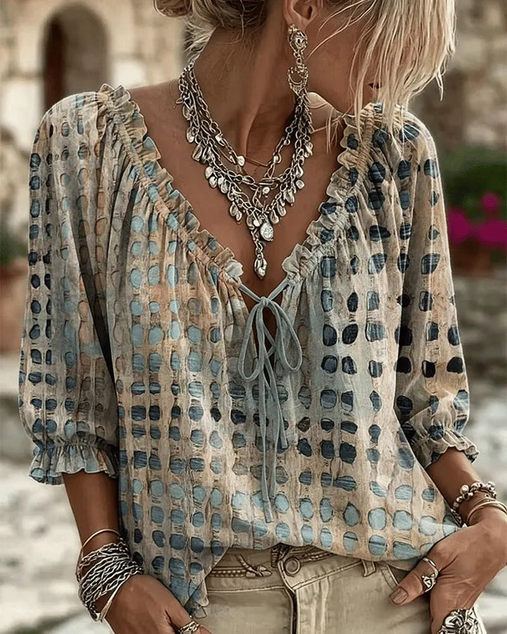 Front view of v-neckline with tie fastening and ruffled puff sleeves, blue
