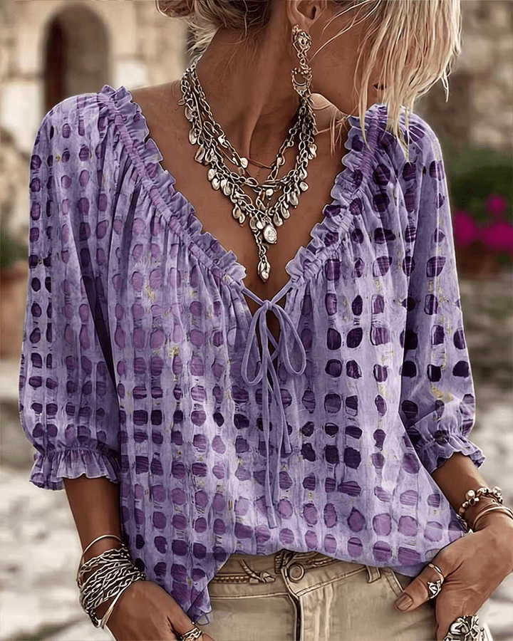 Front view of v-neckline with ruffle trim and tie fastening, puff sleeves, purple