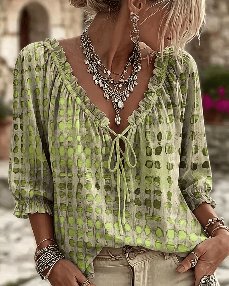 Front view of v-neckline with tie fastening and ruffle trim, puff sleeves, green