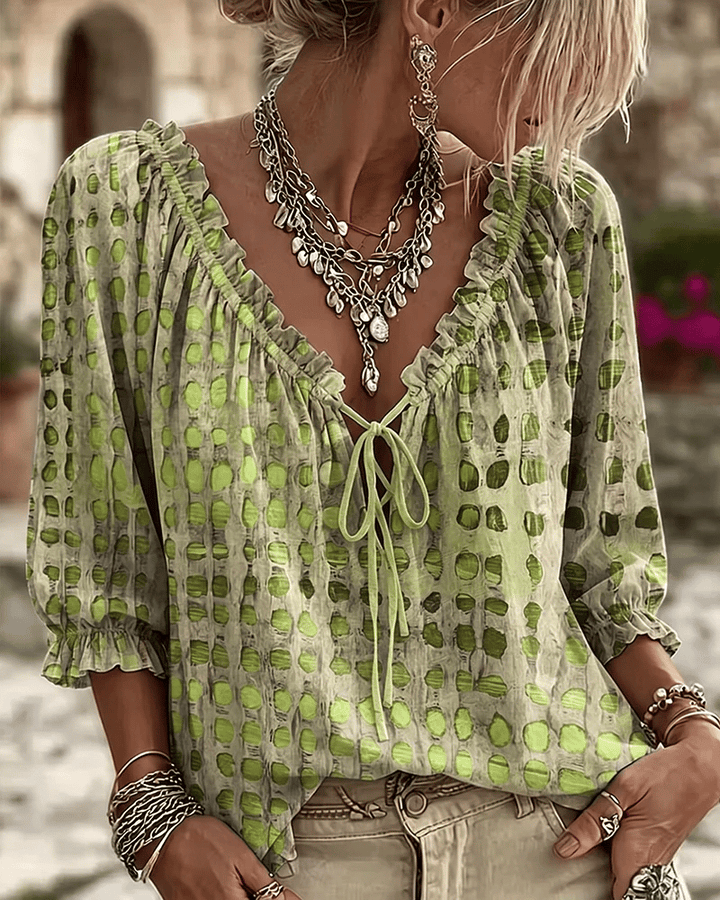 Front view of v-neckline with tie fastening and ruffle trim, puff sleeves, green